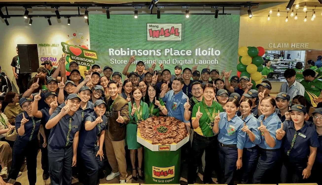 Mang Inasal staff gather around a large platter of grilled chicken at a store launch