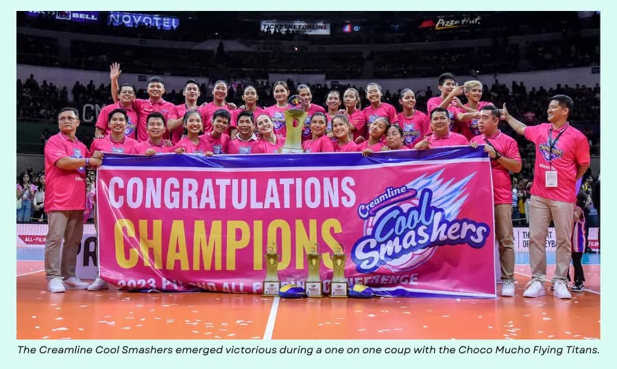 Creamline Cool Smashers players in pink pose with a champions banner